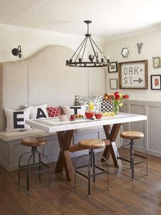 a dining room table with two stools and a bench in front of the table