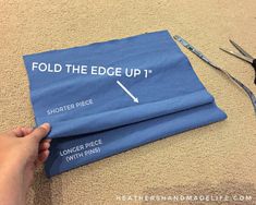 someone is cutting up the edge of a piece of blue fabric