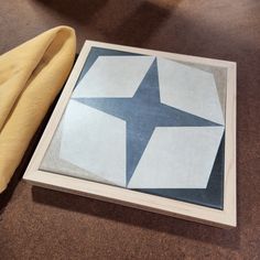 a wooden box with a blue and white star painted on the side next to a yellow towel