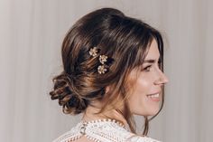 a woman wearing a hair comb with flowers in it's back, looking off to the side