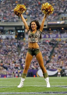 a cheerleader is performing on the field at a football game