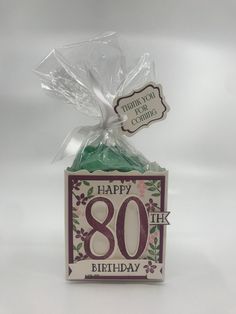 a birthday card with a present wrapped in cellophane and the number 80 on it