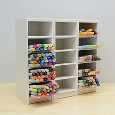 two shelving units with markers and pencils on the top one is open to show pens