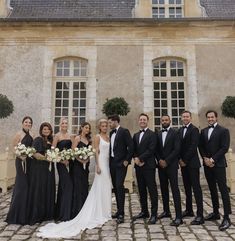 a group of people that are standing in front of a building and posing for a photo