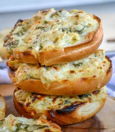 three breads stacked on top of each other with cheese and spinach in the middle