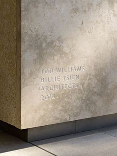 a monument with writing on it in the middle of a sidewalk next to a building