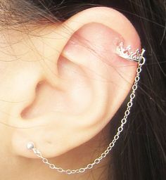 a close up of a person's ear with a chain attached to the side