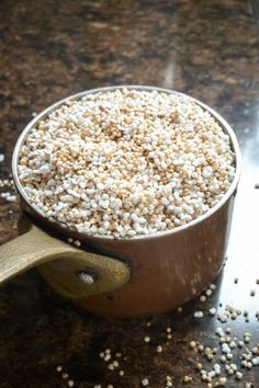 a pot filled with rice sitting on top of a counter next to a glass bottle