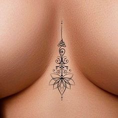 the back of a woman's breast with an intricate tattoo design on her left side