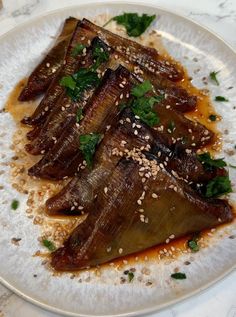 some food on a white plate with sesame seeds