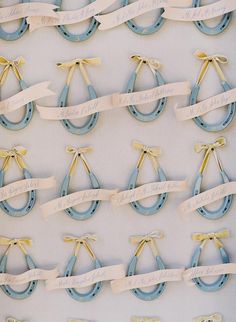 several blue and gold wedding rings with name tags attached to them, hanging on a wall