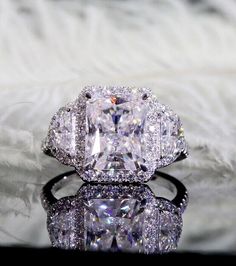 an engagement ring with a cushion cut diamond surrounded by round and baguette diamonds