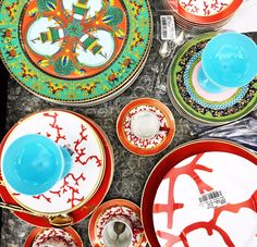 an assortment of colorful plates and bowls on a table