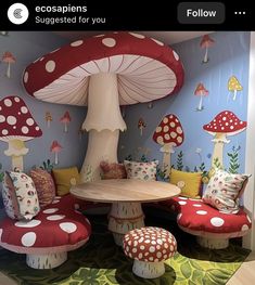 a mushroom themed room with mushrooms on the walls and tables in the middle, surrounded by colorful pillows