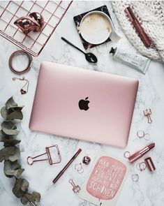 an apple laptop sitting on top of a white table next to other items and accessories