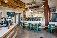 the inside of a restaurant with tables, chairs and washer dryers on the wall