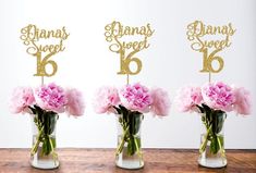 three vases with pink carnations and mr and mrs cake toppers in them