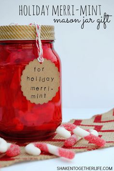 a mason jar filled with candy and marshmallows on top of a table