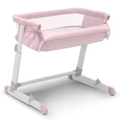 a pink baby crib sitting on top of a white table