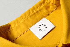 a label on a yellow shirt that says do not touch the buttons or holes in it