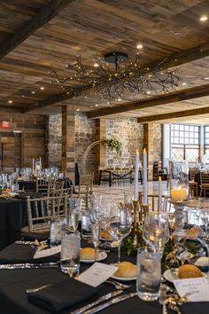 a dining room set up for an event with black linens and silverware on the table