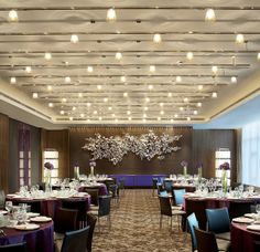 a dining room with tables, chairs and chandeliers