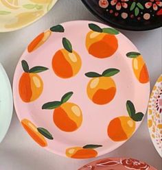 several plates with oranges painted on them