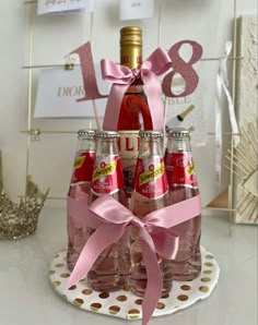 a group of bottles that are sitting on a table with pink ribbon around the bottle