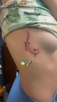 a woman's stomach with a small tattoo on it