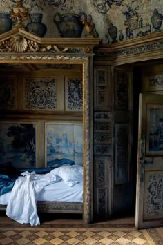 an old fashioned bed in the corner of a room with intricately decorated walls and flooring