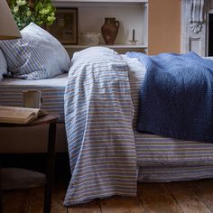 a bed with blue and white striped comforter on top of it next to a fireplace