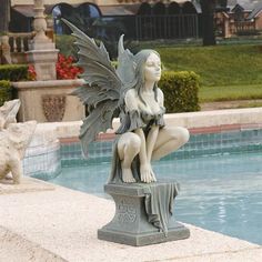 a statue of a fairy sitting on top of a fountain