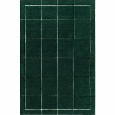 a dark green rug with squares and lines on the bottom, in front of a white background