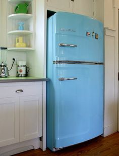 a blue refrigerator sitting in the middle of a kitchen