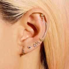 a woman wearing ear piercings with the word love written on it's side