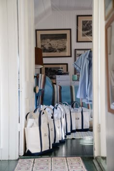 many bags are lined up on the floor in front of an open door to a room