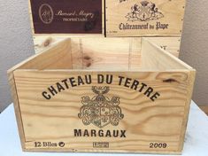 three wooden boxes are stacked on top of each other, one is labeled chateau du terrie margaux