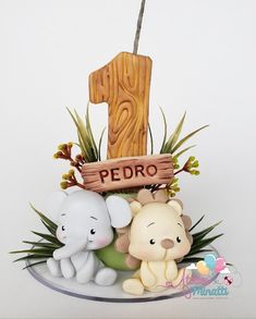 two little elephants sitting next to each other in front of a wooden number one sign