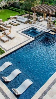 an outdoor swimming pool with lounge chairs around it