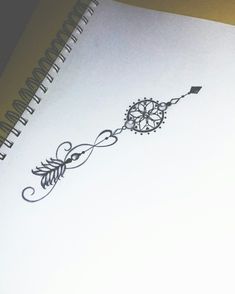 a spiral notebook with an arrow drawn on the page and a pen next to it