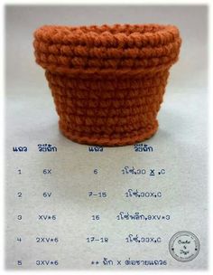 an orange crocheted basket sitting on top of a white table next to a ruler