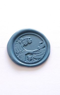 a blue wax seal with an image of a bird on it's back side