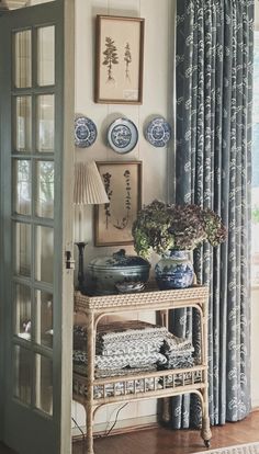 a living room with blue and white decor on the walls, windows, and curtains