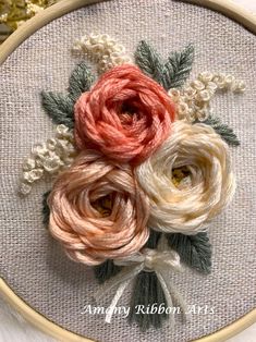 a close up of a flower on a piece of cloth in a hoop with beads