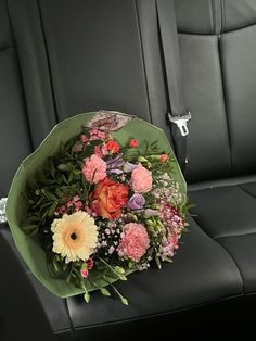 a bouquet of flowers is sitting on the back seat of a car, ready to be delivered