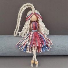 a doll with long hair and braids hanging from a rope