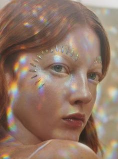 a woman with holographics on her face and body is looking at the camera