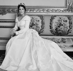 a woman in a white dress sitting on a couch