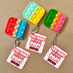 three key chains that have different colors and designs on them, one with an ice cream container in the middle