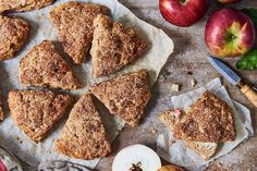 apple pies on parchment paper next to an apple and knife with apples in the background